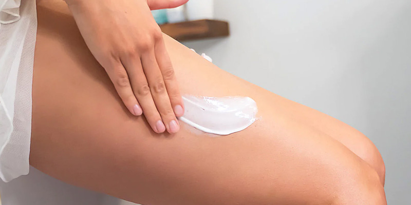 Donna massaggia gambe con crema